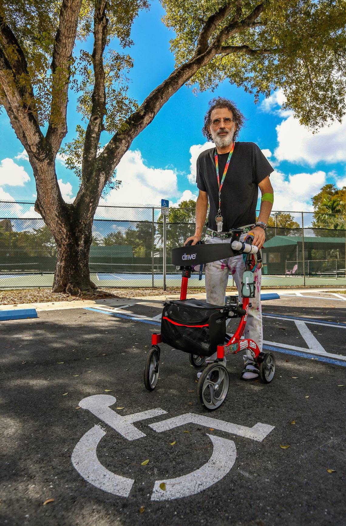 Theo Karantsalis launched a one-man battle to get the city where he lives, Miami Springs, to improve accessibility for the disabled at several locations. Here, he stands at a tennis court complex that he argued did not have adequate handicap parking spaces when he sued in 2019.