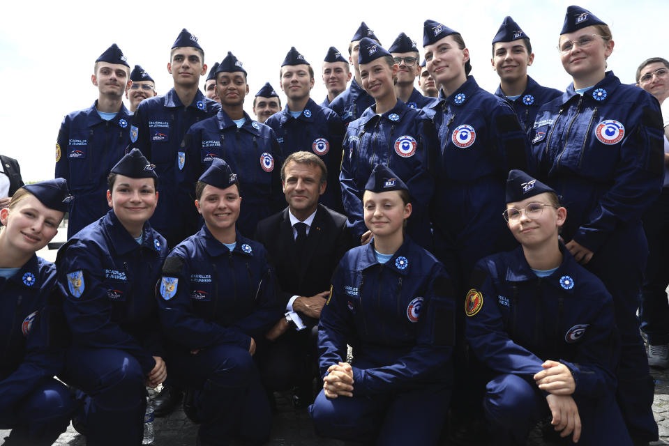 French President Emmanuel Macron poses with members of the Escadrille Jeunesse, a training program for young volunteers in the Air Force, after the Bastille Day military parade Friday, July 14, 2023 in Paris. India is the guest of honor at this year's Bastille Day parade, with Prime Minister Narendra Modi in the presidential tribune alongside French President Emmanuel Macron. (AP Photo/Aurelien Morissard, Pool)