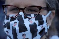 A woman wears a face mask featuring images of recently passed Associate Justice of the Supreme Court of the United States Ruth Bader Ginsburg during for a vigil held in Ginsburg's honor in Washington Square Park in Manhattan, New York City