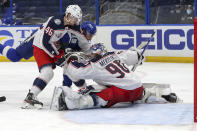 Columbus Blue Jackets goaltender Elvis Merzlikins (90) makes a save against Tampa Bay Lightning's Barclay Goodrow (19) as Dean Kukan (46) defends during the second period of an NHL hockey game Thursday, April 22, 2021, in Tampa, Fla. (AP Photo/Mike Carlson)