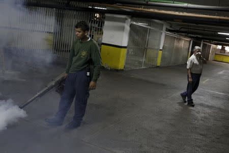 A municipal worker fumigates inside a building to help control the spread of the mosquito-borne Zika virus in Caracas, February 2, 2016. REUTERS/Marco Bello