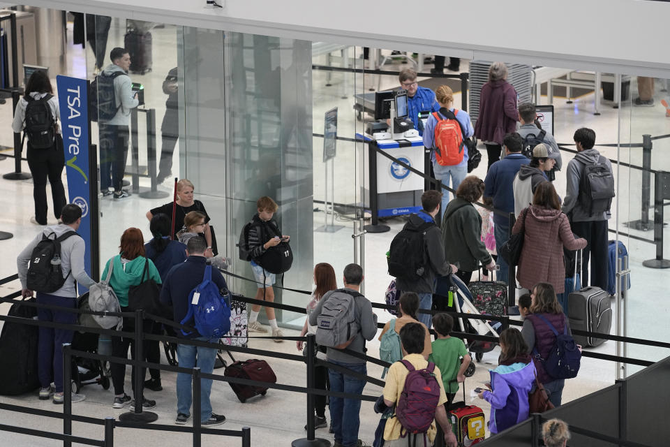 Travelers wait in line before going through a security checkpoint at the Nashville International Airport, Tuesday, Nov. 21, 2023, in Nashville, Tenn. Despite inflation and memories of past holiday travel meltdowns, millions of people are expected to hit airports and highways in record numbers over the Thanksgiving Day break. (AP Photo/George Walker IV)