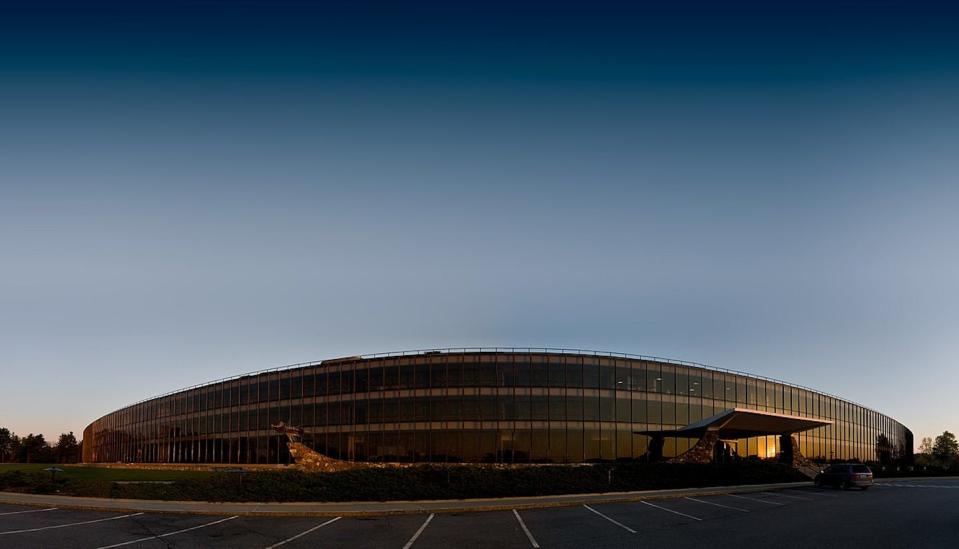 Un edificio redondo de oficinas iluminado en un atardecer.