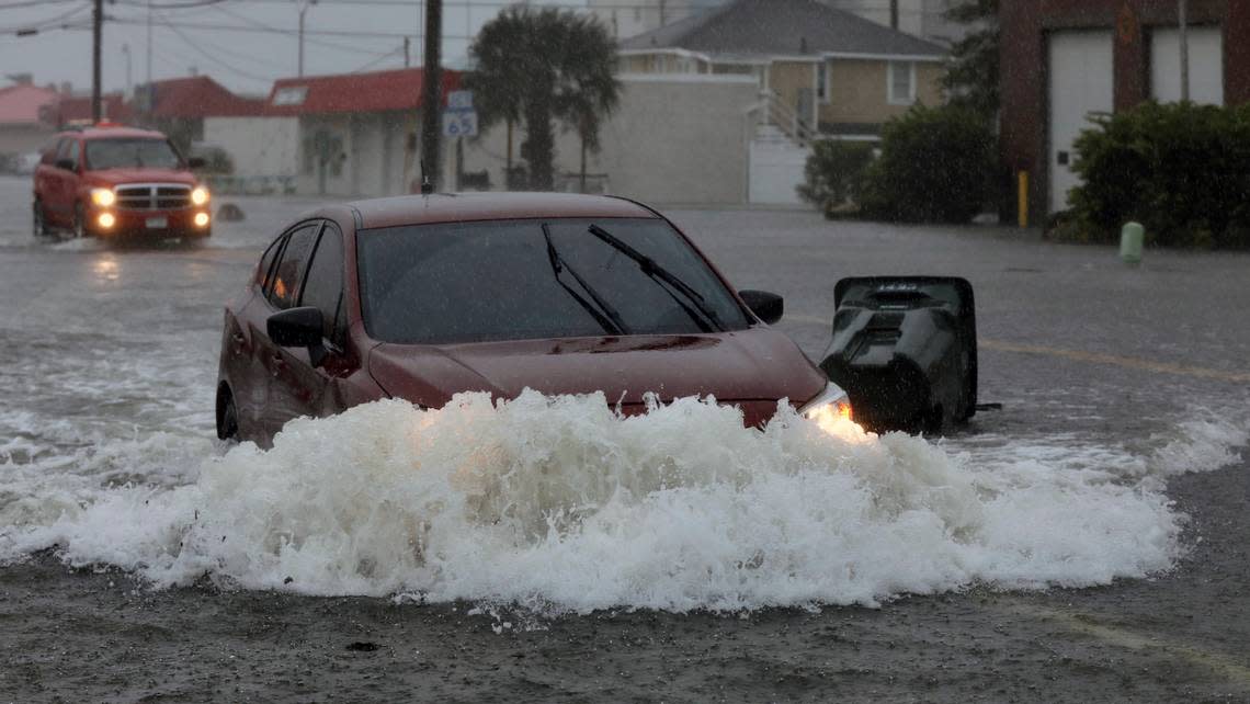 Cars make their way through dangerously flooded streets the Cherry Grove and North Myrtle Beach area as storm surge pushed Hog Inlet over its banks around 1 p.m. The surge came as Hurricane Ian approached landfall in South Carolina.