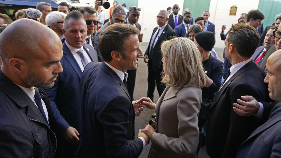 French President Emmanuel Macron and his wife Brigitte Macron greet the crowd as they arrive at Jackson Square in New Orleans, Friday, Dec. 2, 2022. (AP Photo/Gerald Herbert)