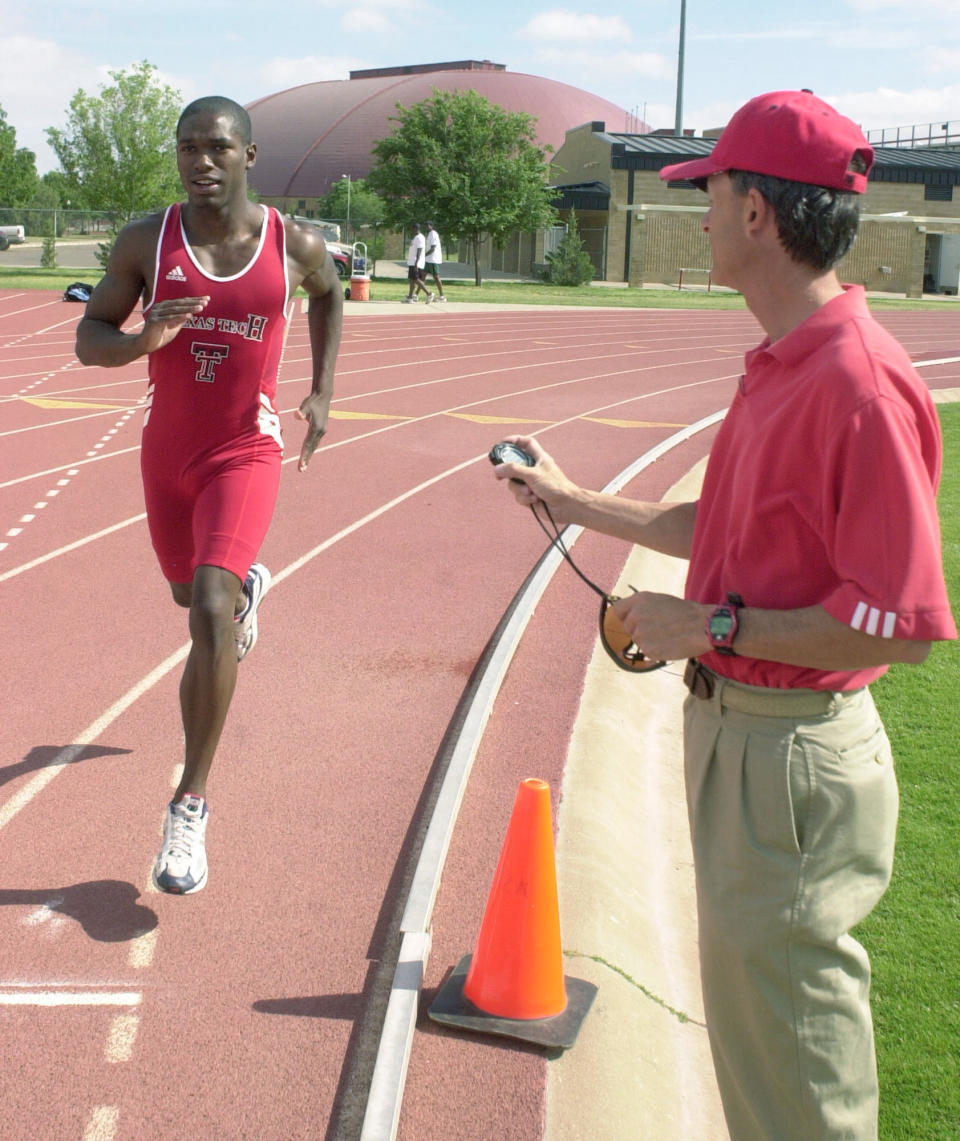 FILE - Texas Tech runner Jonathan Johnson, left, is timed during practice by track coach Wes Kittley, on May 20, 2004, in Lubbock, Texas. Johnson competes in the 800-meter run this week at the NCAA national meet in Austin, Texas. Texas Tech offensive coordinator Zach Kittley is the son of the longtime Texas Tech track coach and NCAA championship winner Wes Kittley. The younger Kittley was always consumed by football growing up. (AP Photo/Joe Don Buckner, File)