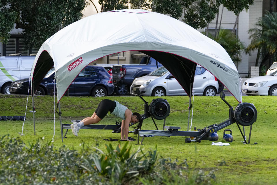 A woman workout in a park in the eastern suburbs of Sydney Tuesday, Sept. 14, 2021. Personal trainers have turned a waterfront park at Sydney’s Rushcutters Bay into an outdoor gym to get around pandemic lockdown restrictions. (AP Photo/Mark Baker)