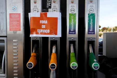 FILE PHOTO: A sign reading "Out of service" hangs on fuel pumps at a petrol station during a fuel strike, near Lisbon