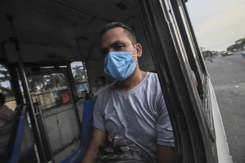 A man wears a mask against the spread of COVID-19 disease, as he rides a bus home in Managua, Nicaragua, Monday, May 11, 2020. President Daniel Ortega's government has stood out for its refusal to impose measures to halt the new coronavirus for more than two months since the disease was first diagnosed in Nicaragua. Now, doctors and family members of apparent victims say, the government has gone from denying the disease's presence in the country to actively trying to conceal its spread. (AP Photo/Alfredo Zuniga)