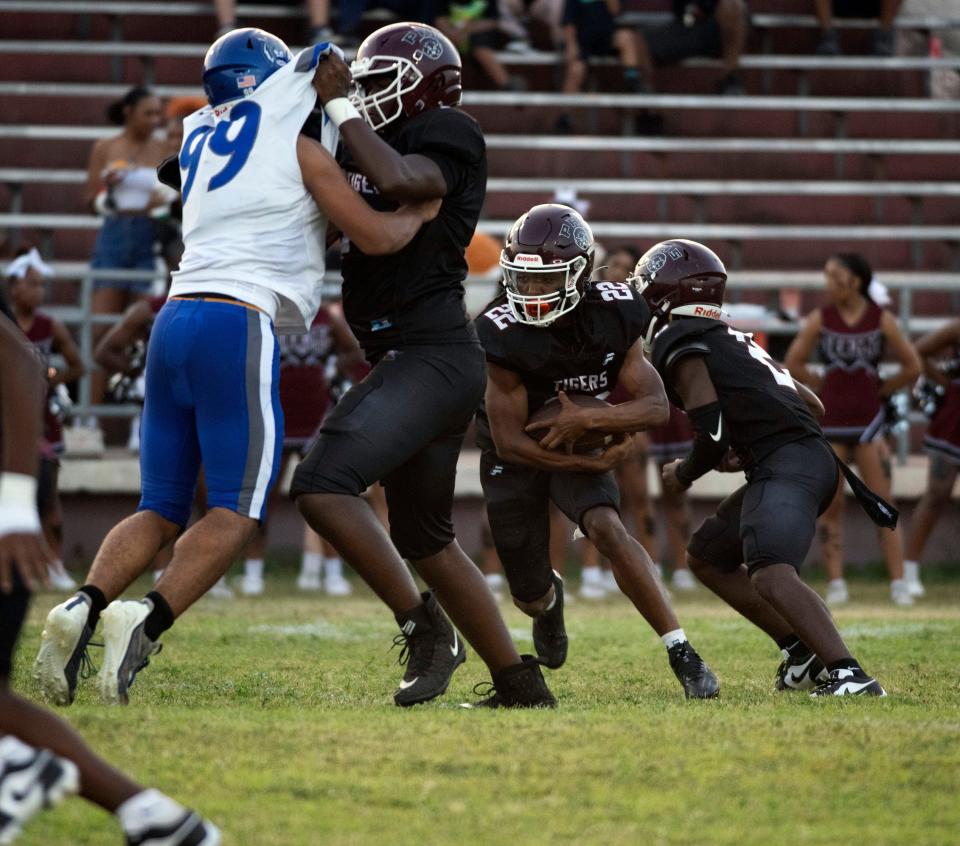 Pensacola High School running back Aaron Dean (No. 22) looks to take advantage of a hole in the Washington line created by the offensive line during Friday night's home opener.