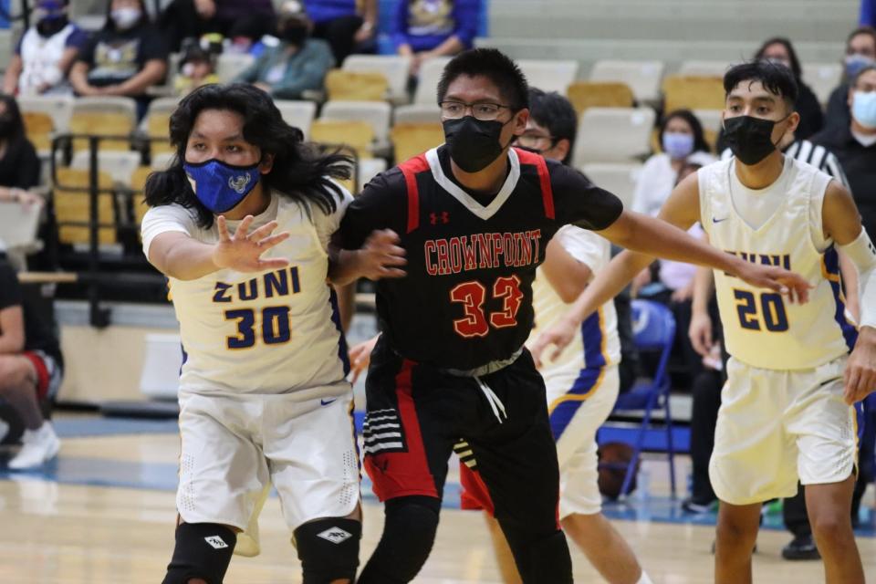 Crownpoint's Quincy Benally looks to receive a pass while fending off Zuni defender Kole Eriacho during a basketball game Thursday, Jan. 20, 2022 at Zuni High School.