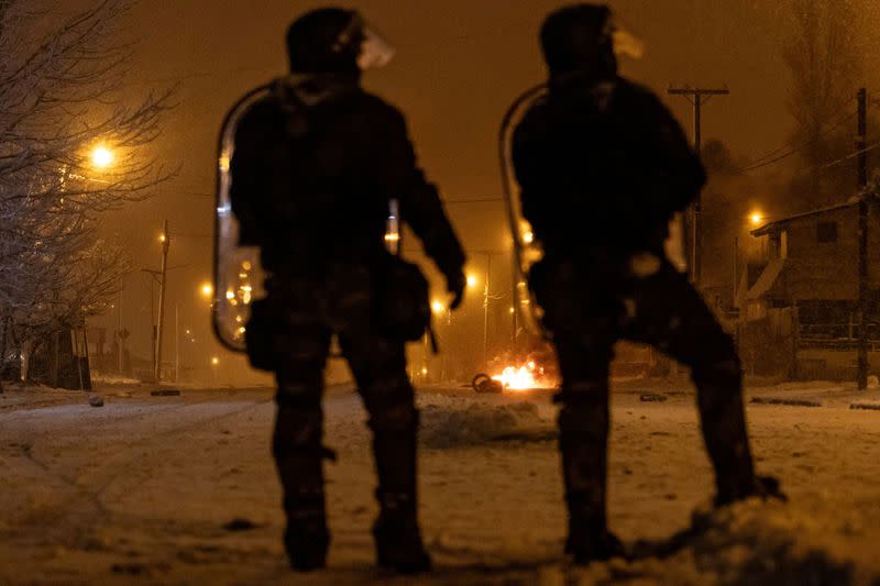 Police forces stand guard after local residents attempted to loot a supermarket in the southern town of Bariloche, Patagonia Region