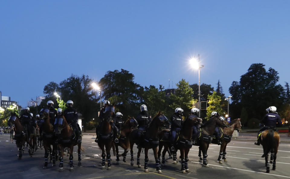 Serbian police on horses guard the area during clashes with protesters in Belgrade, Serbia, Wednesday, July 8, 2020. Serbia's president Aleksandar Vucic backtracked Wednesday on his plans to reinstate a coronavirus lockdown in Belgrade after thousands protested the move and violently clashed with the police in the capital. (AP Photo/Darko Vojinovic)