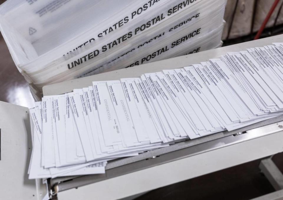 Sealed paychecks for California state workers are handled by a mail machine on Aug. 24.