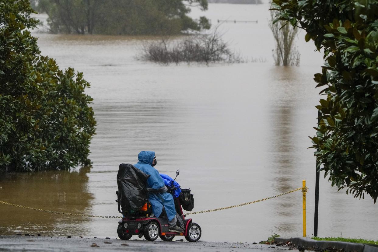 A woman looks over the flooded farmland at Richmond on the outskirts of Sydney, Australia, Monday, July 4, 2022.