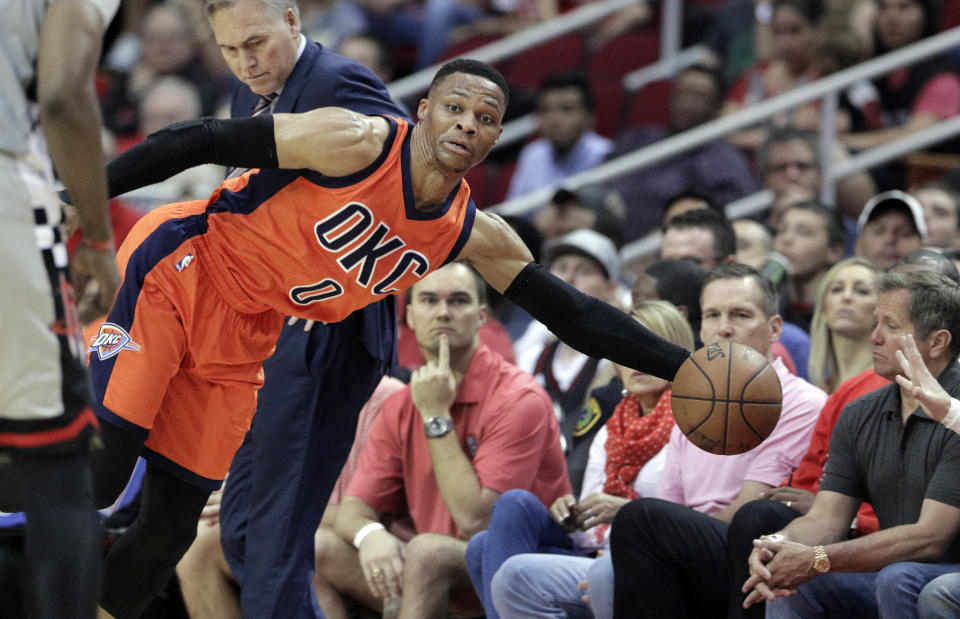 Oklahoma City Thunder's Russell Westbrook (0) dives to keep the ball inbounds against the Houston Rockets in the second half of an NBA basketball game in Houston, Sunday, March 26, 2017. (AP Photo/Michael Wyke)