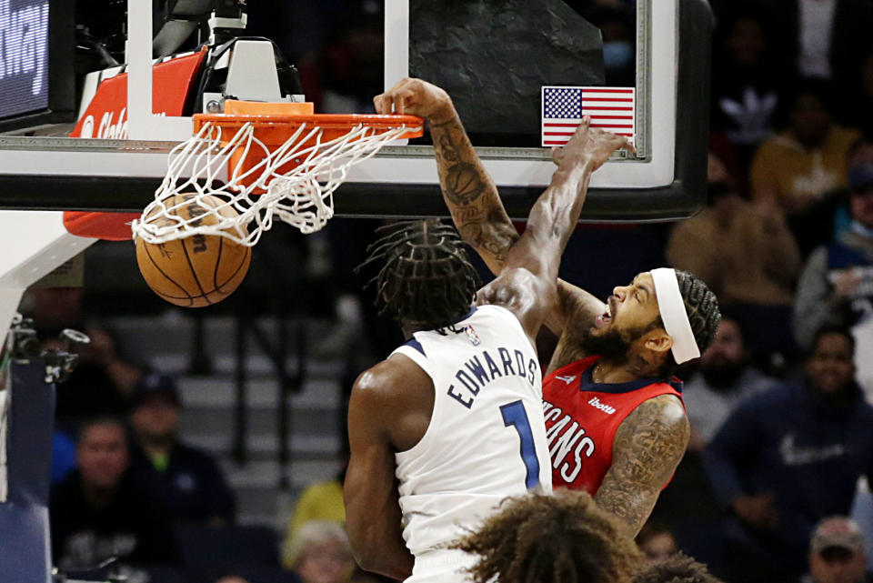 New Orleans Pelicans forward Brandon Ingram (14) dunks in front of Minnesota Timberwolves forward Anthony Edwards (1) in the second half of an NBA basketball game, Monday, Oct. 25, 2021, in Minneapolis. (AP Photo/Andy Clayton-King)