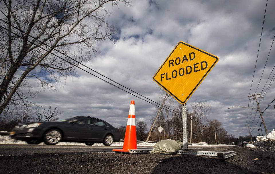 A car approaches a partially flooded street following a massive snow storm in West Seneca, New York November 24, 2014. Emergency workers filled thousands of sandbags on Sunday as the area around Buffalo, New York braced for potential flooding as warming temperatures began to melt up to seven feet (2 metres) of snow. (REUTERS/Mark Blinch)