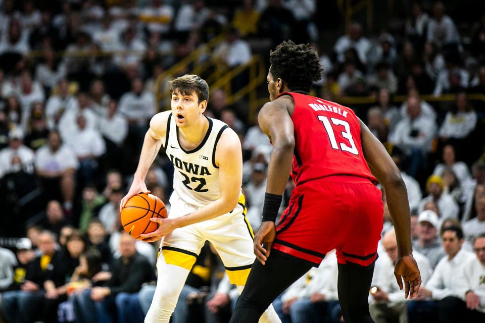 Iowa forward Patrick McCaffery (22) dribbles as Rutgers forward Antwone Woolfolk (13) defends during a NCAA Big Ten Conference men's basketball game, Sunday, Jan. 29, 2023, at Carver-Hawkeye Arena in Iowa City, Iowa.