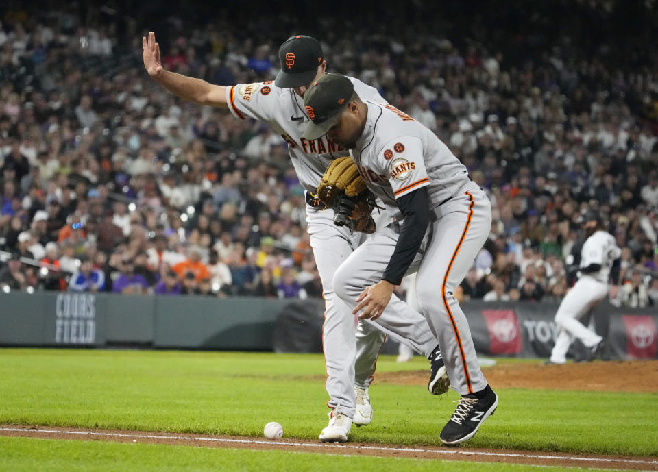 San Francisco Giants relief pitcher Tyler Rogers, left, and first baseman LaMonte Wade Jr., right, wait for the ball bit by Colorado Rockies' Ezequiel Tovar to roll foul in the seventh inning of the second baseball game of a doubleheader, Saturday, Sept. 16, 2023, in Denver. (AP Photo/Jack Dempsey)