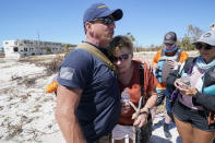 Resident Judy Hicks is embraced by Project DYNAMO rescuer Bryon Wheeldon, before she is taken off the island, in the wake of Hurricane Ian, Friday, Sept. 30, 2022, on Sanibel Island, Fla. (AP Photo/Steve Helber)