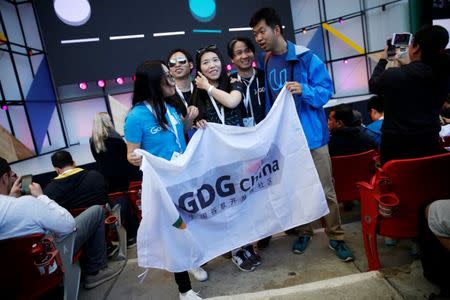 A group of attendees stand for a photo while holding a flag before the opening keynote at the annual Google I/O developers conference in San Jose, California, U.S., May 17, 2017. REUTERS/Stephen Lam