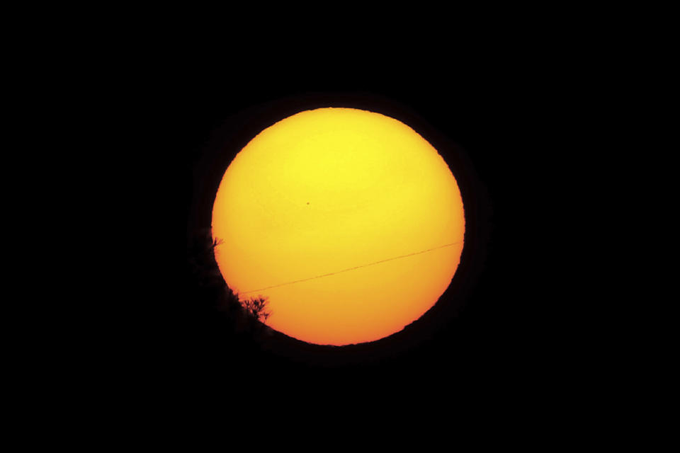 Planet Mercury is seen as a small silhouette, center left, as it travels across the face of the sun, near capital Nicosia, Cyprus, Monday, Nov. 11, 2019. The solar system's smallest, innermost planet will resemble a tiny black dot Monday as it passes directly between Earth and the sun. (AP Photo/Petros Karadjias)