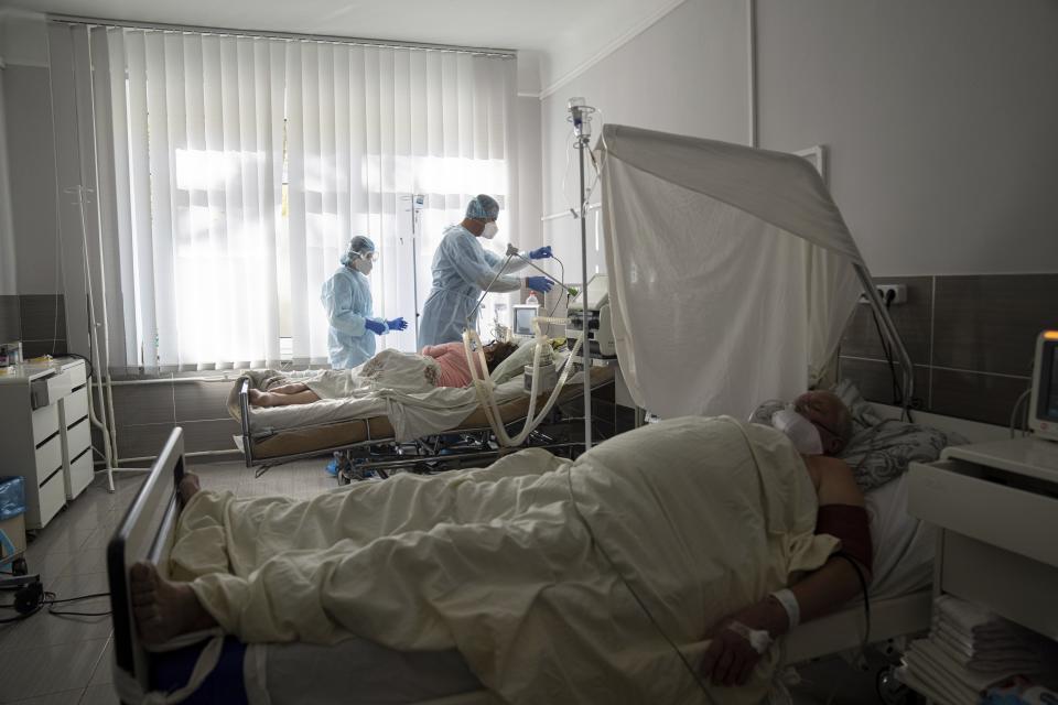 FILE - In this Friday, Oct. 22, 2021 file photo, medical staff treat a patient with coronavirus at an ICU of the city hospital 1 in Rivne, 300 kilometers (190 miles) west of Kyiv, Ukraine. Ukraine is suffering through a surge in coronavirus infections, along with other parts of Eastern Europe and Russia. While vaccines are plentiful, there is a widespread reluctance to get them in many countries — though notable exceptions include the Baltic nations, Poland, the Czech Republic, Slovenia and Hungary. (AP Photo/Evgeniy Maloletka, File)