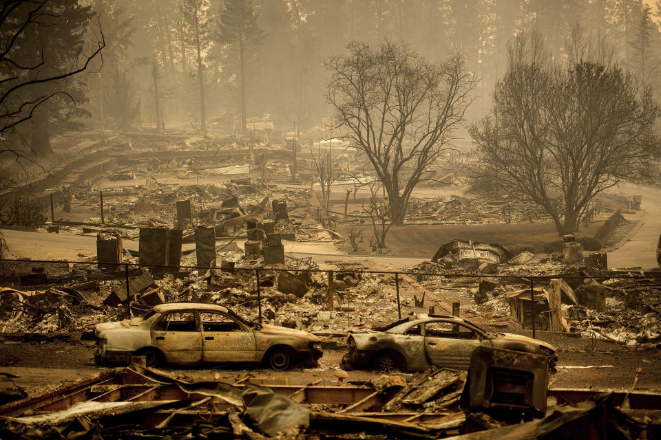 FILE - In this Nov. 12, 2018, file photo, homes leveled by the Camp Fire line a development on Edgewood Lane in Paradise, Calif. Pacific Gas and Electric says it has reached a $13.5 billion settlement that will resolve all major claims related to devastating wildfires blamed on its outdated equipment and negligence. The settlement, which the utility says was reached Friday, Dec. 6, 2019, still requires court approval. (AP Photo/Noah Berger, File)