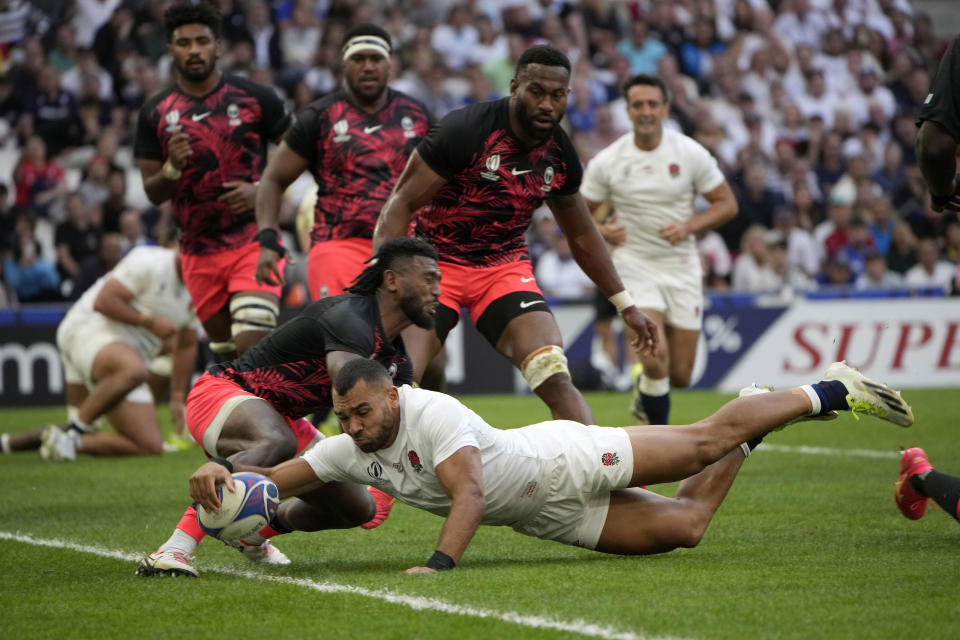 England's Joe Marchant dives to score a try during the Rugby World Cup quarterfinal match between England and Fiji at the Stade de Marseille in Marseille, France, Sunday, Oct. 15, 2023. (AP Photo/Laurent Cipriani)