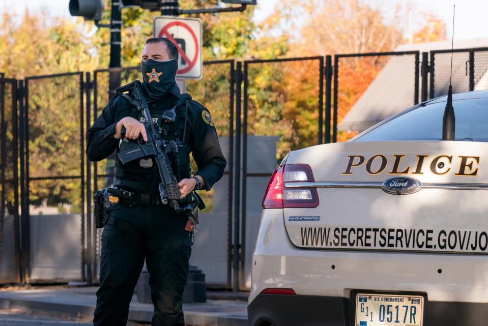 A U.S. Secret Service officer stands guard as President Donald Trump's motorcade arrives at the White House on Nov. 8, 2020.