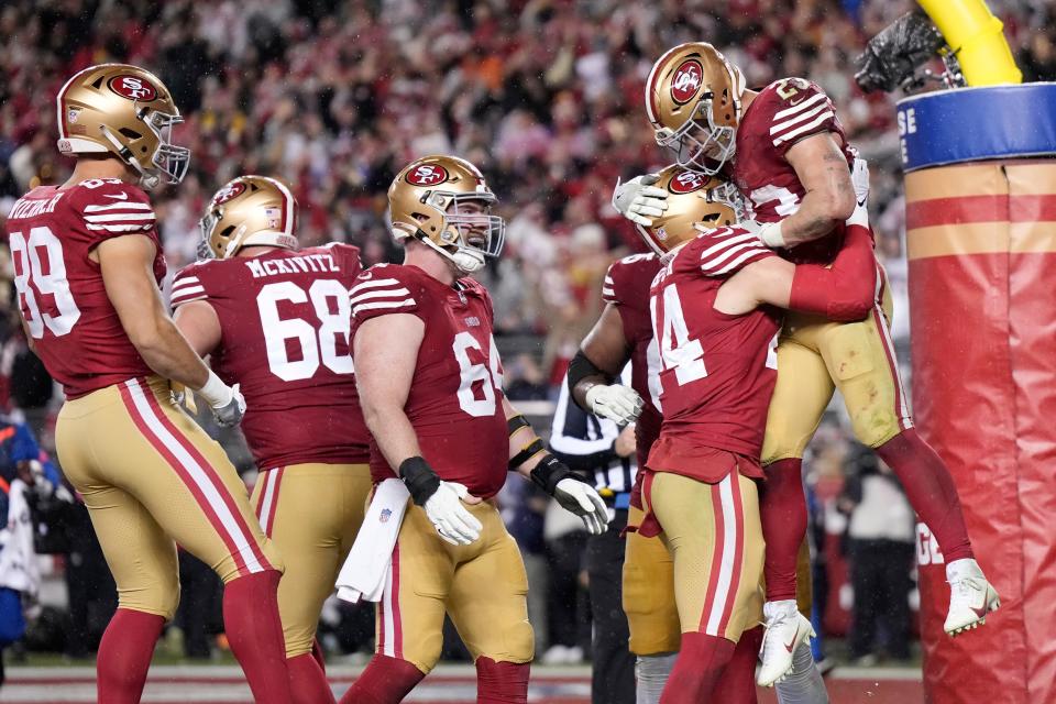 SANTA CLARA, CALIFORNIA - JANUARY 20: Christian McCaffrey #23 of the San Francisco 49ers celebrates with teammates after scoring a 6-yard rushing touchdown during the fourth quarter against the Green Bay Packers in the NFC Divisional Playoffs at Levi's Stadium on January 20, 2024 in Santa Clara, California. (Photo by Thearon W. Henderson/Getty Images)