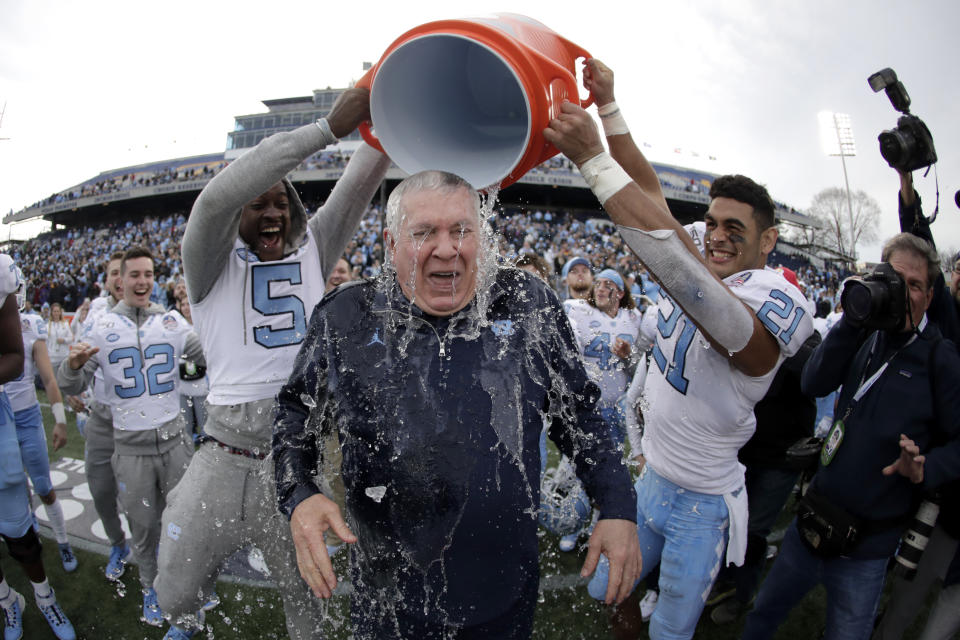 North Carolina head coach Mack Brown, center, is doused by defensive back Patrice Rene, left, and linebacker Chazz Surratt during the second half of the Military Bowl NCAA college football game against Temple, Friday, Dec. 27, 2019, in Annapolis, Md. (AP Photo/Julio Cortez)