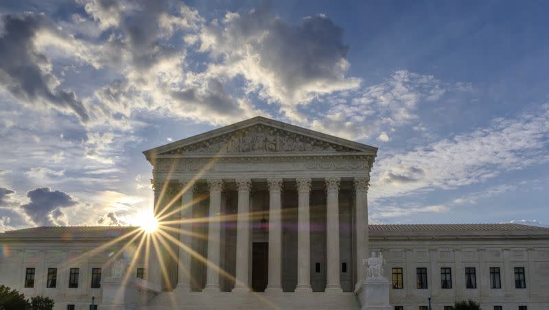 The sun flares in the camera lens as it rises behind the U.S. Supreme Court building in Washington on June 25, 2017.