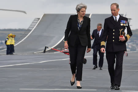 Britain's Prime Minister Theresa May talks with Commodore Jerry Kyd, Captain of the British aircraft carrier HMS Queen Elizabeth, during her tour of the ship, after it arrived at Portsmouth Naval base, its new home port, in Portsmouth, Britain August 16, 2017. REUTERS/Ben Stansall/Pool