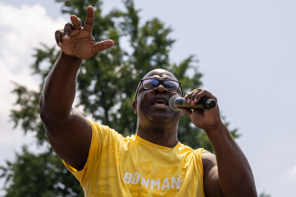 Representative Jamaal Bowman holds a microphone as he speaks at a rally.