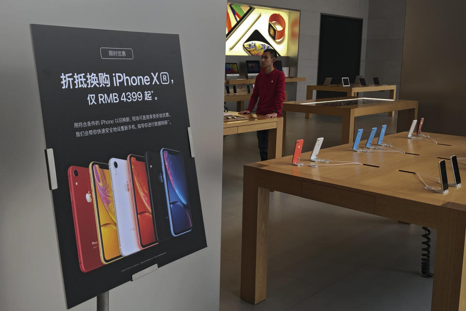 A trade-in for iPhone XR promotion board is displayed as an Apple employee waits for customer at its retail store in Beijing, Thursday, Jan. 3, 2019. Apple Inc.’s $1,000 iPhone is a tough sell to Chinese consumers who are jittery over an economic slump and a trade war with Washington. The tech giant became the latest global company to collide with Chinese consumer anxiety when CEO Tim Cook said iPhone demand is waning, due mostly to China. Weak consumer demand in the world’s second-largest economy is a blow to industries from autos to designer clothing that are counting on China to drive revenue growth. (AP Photo/Andy Wong)