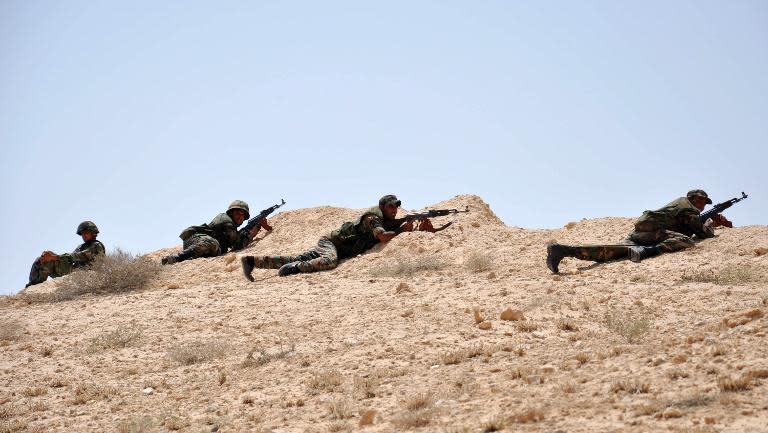 Syrian soldiers hold a position during clashes with Islamic State (IS) group jihadists in northeastern Palmyra on May 17, 2015