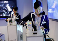 Staff dressed as flight attendants, serve drinks to guests at the "First Airlines", virtual first-class airline experience facility in Tokyo, Japan February 14, 2018. Picture taken February 14, 2018. REUTERS/Toru Hanai