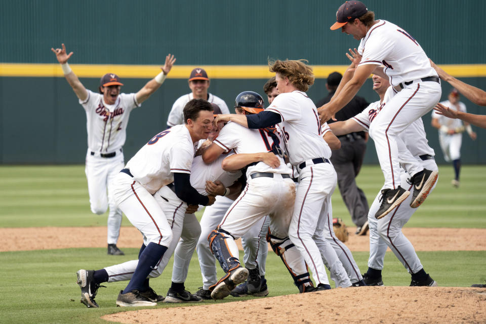 Virginia players celebrate after an NCAA college baseball tournament super regional game against Dallas Baptist, Monday, June 14, 2021, in Columbia, S.C. (AP Photo/Sean Rayford)