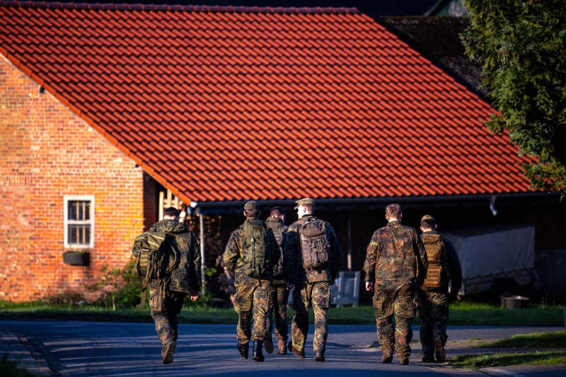 Armed forces officers walk through the missing boy's home. Six-year-old Arian from Elm is still missing as the search for him continues. Sina Schuldt/dpa