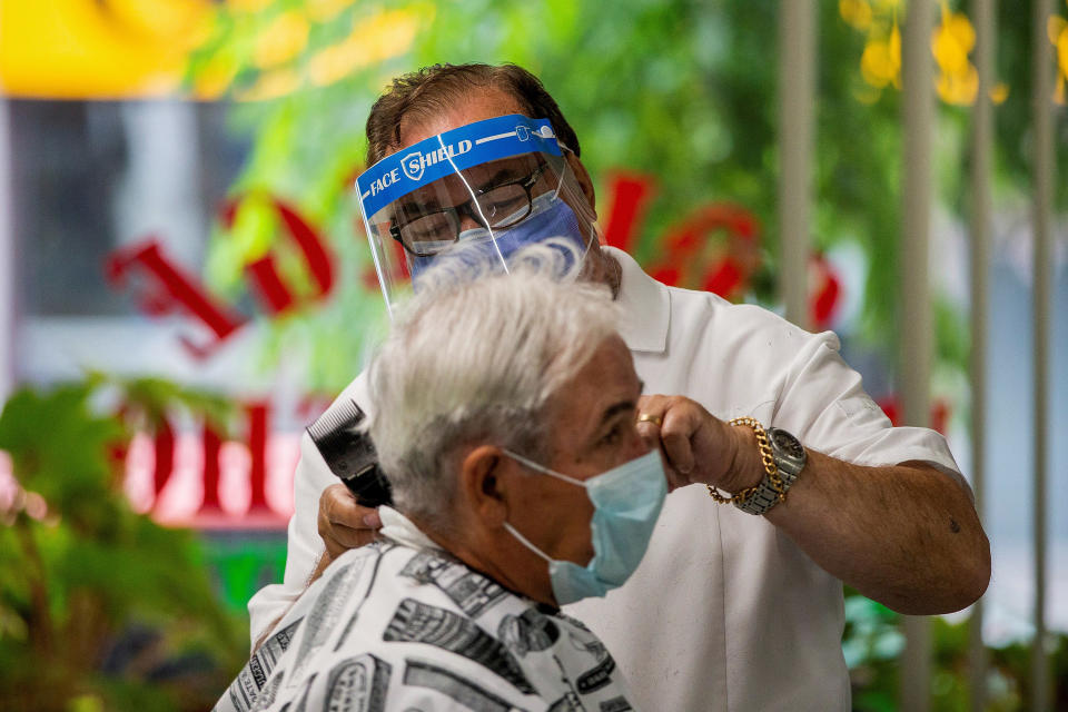 Image: A barber in Toronto (Carlos Osorio / Reuters)