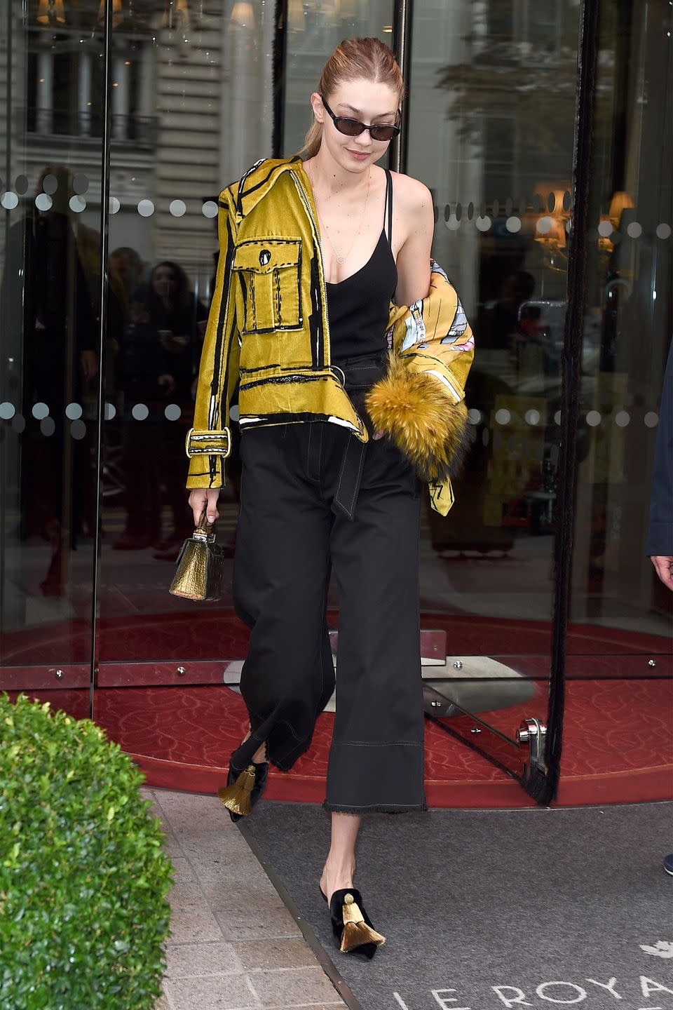 <p>In a mustard yellow Edda Gimnes jacket designed by her stylist Mimi Cuttrell, gold leather bag by Stalvey, black tank top, black frayed-hem cutlottes, tasseled mules, and oval sunglasses while out in Paris.</p>