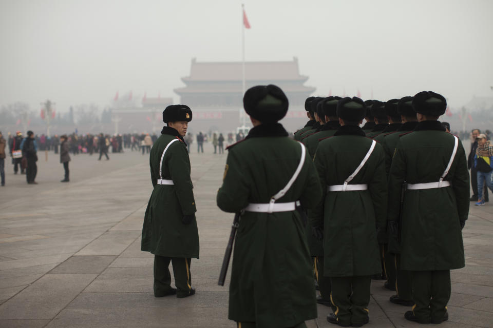 Paramilitary policemen stand ready to march across Tiananmen Square on a severely polluted day in Beijing, China, Tuesday, Feb. 25, 2014. Pollution across a large swath of northern China worsened on Tuesday. (AP Photo/Alexander F. Yuan)