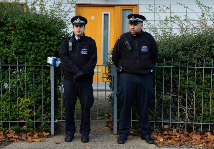Police stand guard outside a block of residential flats in south London on November 23, 2013 after the recent discovery of three women held captive for 30 years (AFP Photo/Leon Neal)