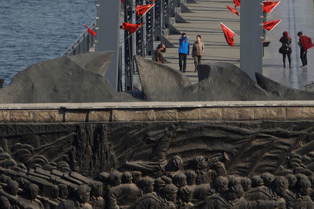 Tourists walk on the Broken Bridge, bombed by the U.S. forces in the Korean War and now a tourist site, over the Yalu River that divides North Korea and China, in Dandong, China's Liaoning province, April 13, 2017. REUTERS/Aly Song