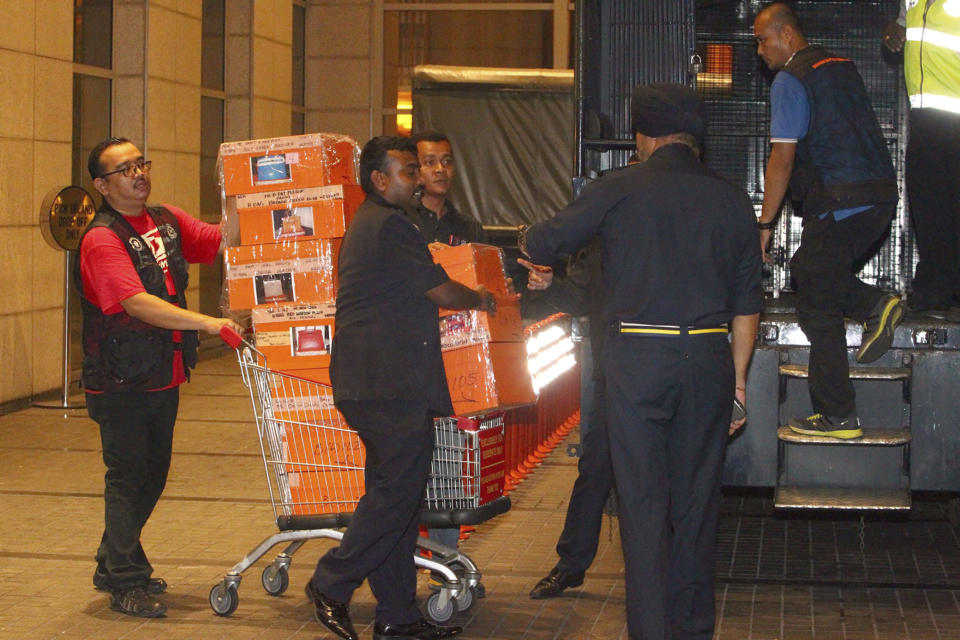 FILE - Police prepare to load confiscated items into a truck in Kuala Lumpur, Malaysia, May 18, 2018. Najib Razak on Tuesday, Aug. 23, 2022 was Malaysia’s first former prime minister to go to prison -- a mighty fall for a veteran British-educated politician whose father and uncle were the country’s second and third prime ministers, respectively. The 1MDB financial scandal that brought him down was not just a personal blow but shook the stranglehold his United Malays National Organization party had over Malaysian politics. (AP Photo, file)