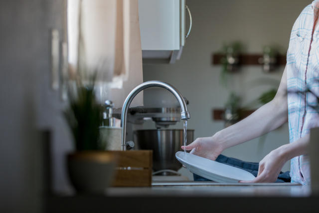 Woman Loading Washing Machine In Kitchen High-Res Stock Photo - Getty Images