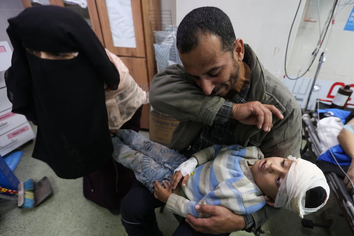 A Palestinian boy wounded in an Israeli strike is carried to Nasser Hospital in western Khan Younis this morning  (Reuters)