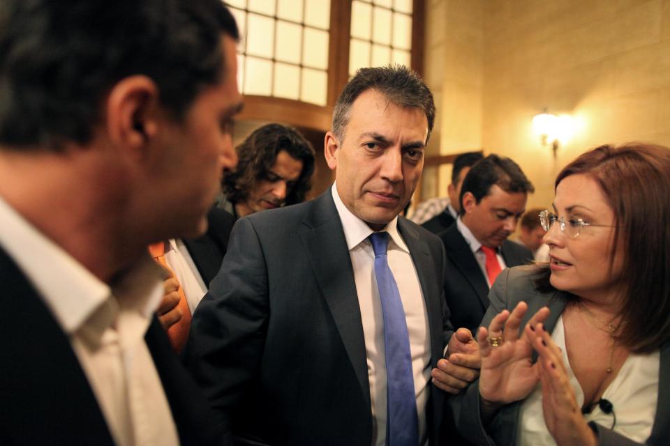 Greek Labor Minister Yiannis Droutsis, center, chats with journalists as he leaves Prime Minister Antonis Samaras' office inside the Greek Parliament, in Athens on Tuesday, Oct. 16, 2012. Greece has been surviving on emergency loans from eurozone countries and the International Monetary Fund for more than two years. It is currently locked in protracted negotiations with rescue creditors for a major new austerity package that is set to take the country into a sixth year of recession in 2013. (AP Photo/Petros Giannakouris)